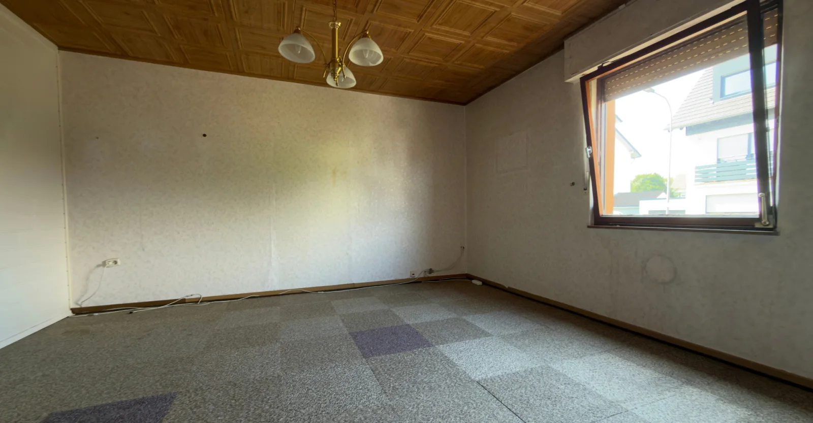 Vorher: Leeres Esszimmer mit Holzdecke und Teppichfliesen in einem Sanierungsobjekt in Stuttgart vor der virtuellen Sanierung.