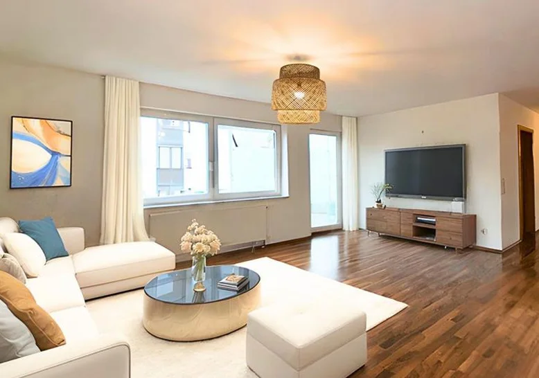 Nachher: Virtuell eingerichtetes Wohnzimmer in Hechingen mit Ecksofa und TV-Bereich. Virtuelles Home Staging von Stagingwerk, mit KI erstellt.